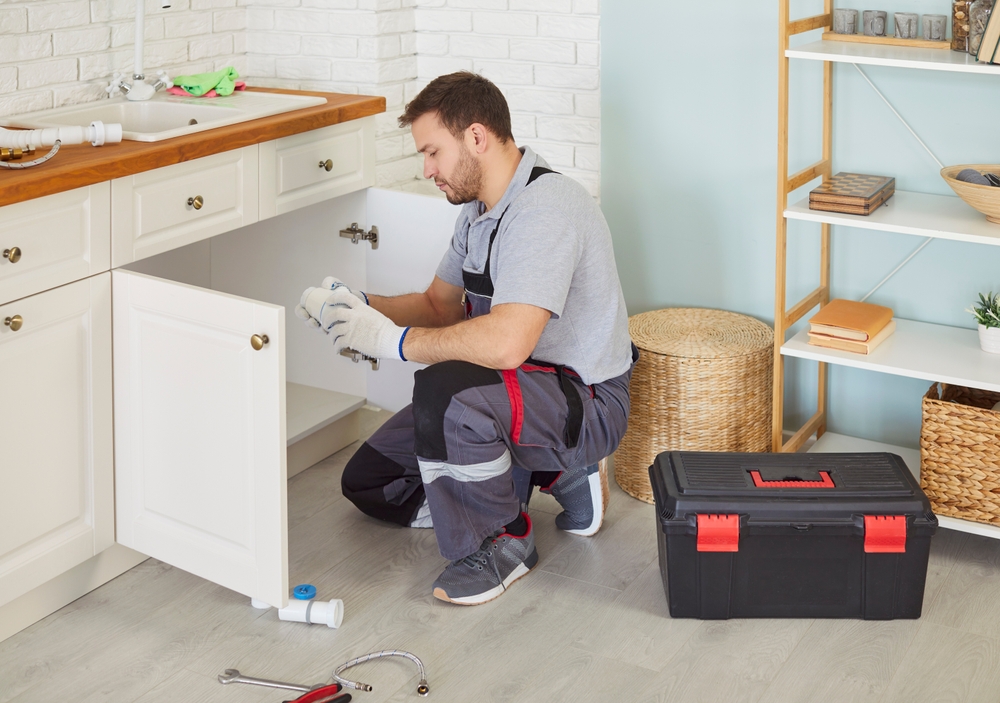plumber working on garbage disposal